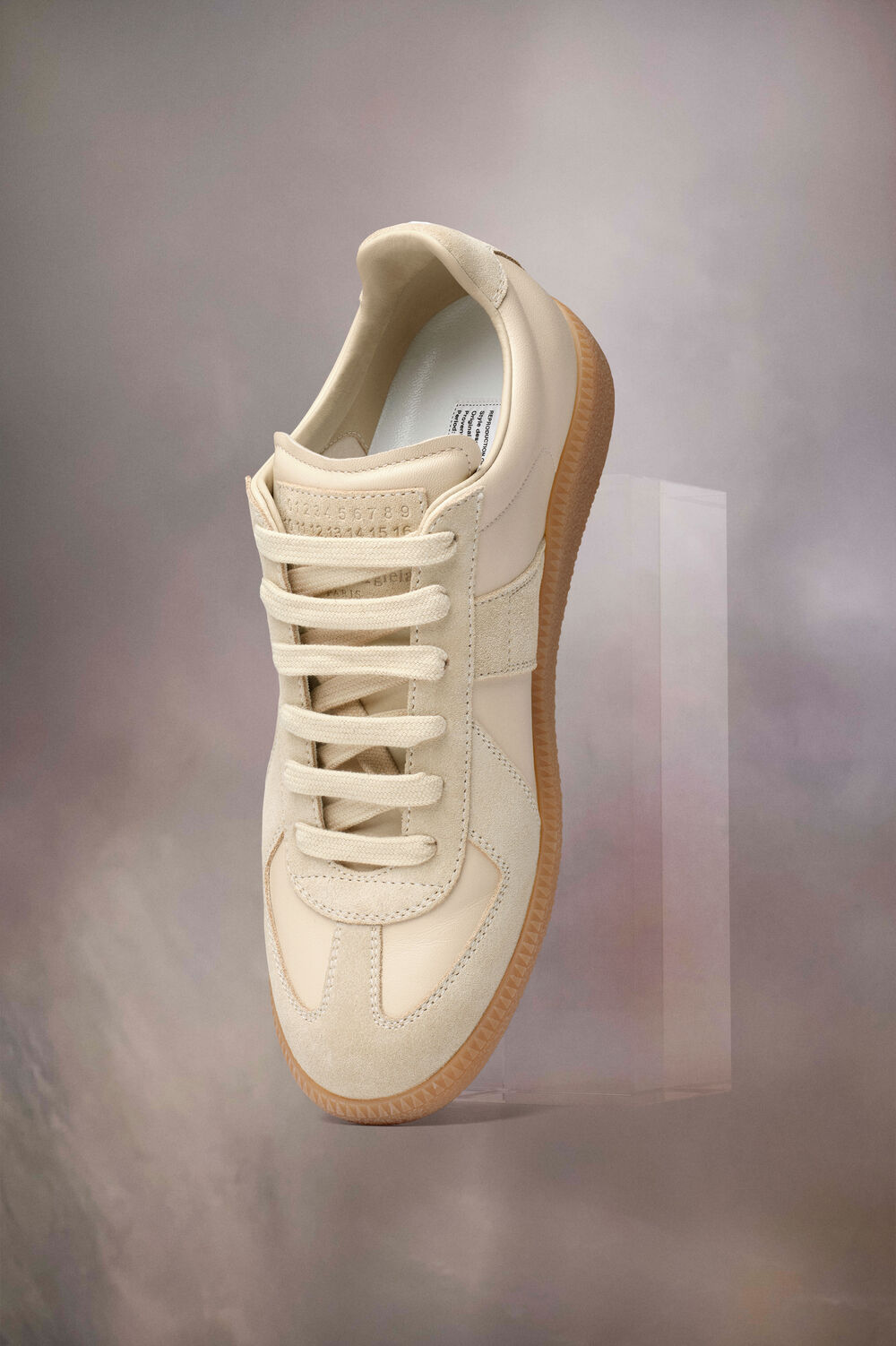 Maison Margiela’s characteristic shoes are emblems in their own right. Designed by Creative Director John Galliano, the seasonal shoe collections consistently evolve the classic codes of the house while pushing the boundaries of craftsmanship. With its iconic split-toe, the house’s trademark Tabi silhouette is interpreted across styles, along with new adaptations of the hallmark Replica sneakers. Proposals reimagine the tropes of shoe-making in leather or mixed materials: flats traverse trainers, ballerinas, sandals, loafers, derbies and brogues, while heels manifest in pumps, mules, Mary-Janes, and boots expressed with platforms and block or chunky heels.